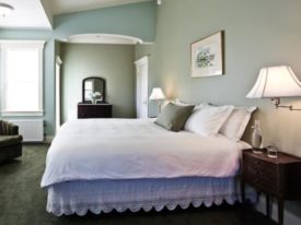green room with bed and white bedspread