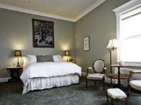 bed with white bedspread in green room