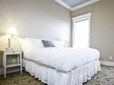 bed with white bedspread and lamp on nightstand